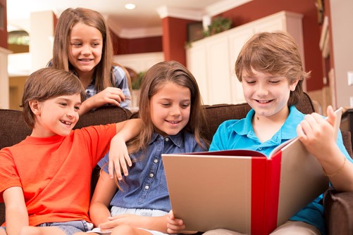 Kinderen lezen boek op bank