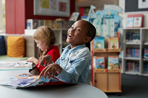 Meisje lacht in de bibliotheek 