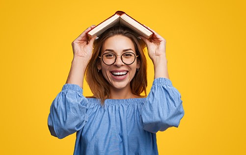 Vrouw houdt een boek boven haar hoofd