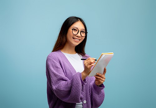 Vrouw maakt oogcontact en schrijft iets op