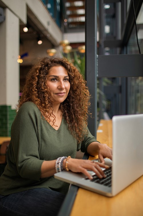 Vrouw met krullen achter de computer